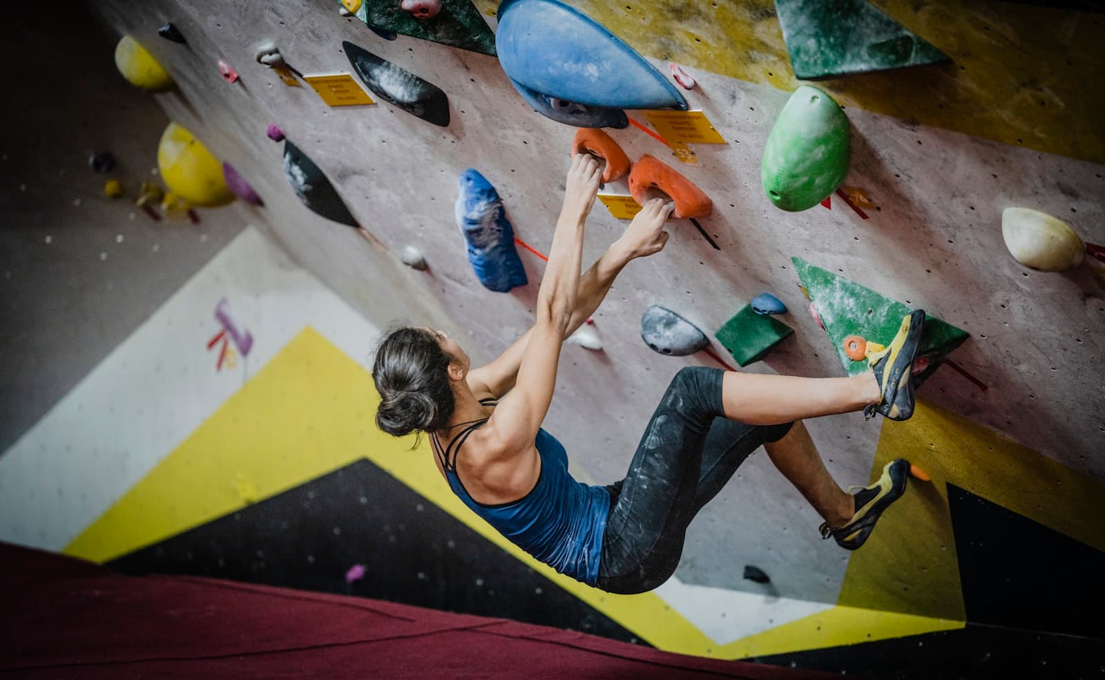 Climber on an overhanging boulder route in an indoor gym