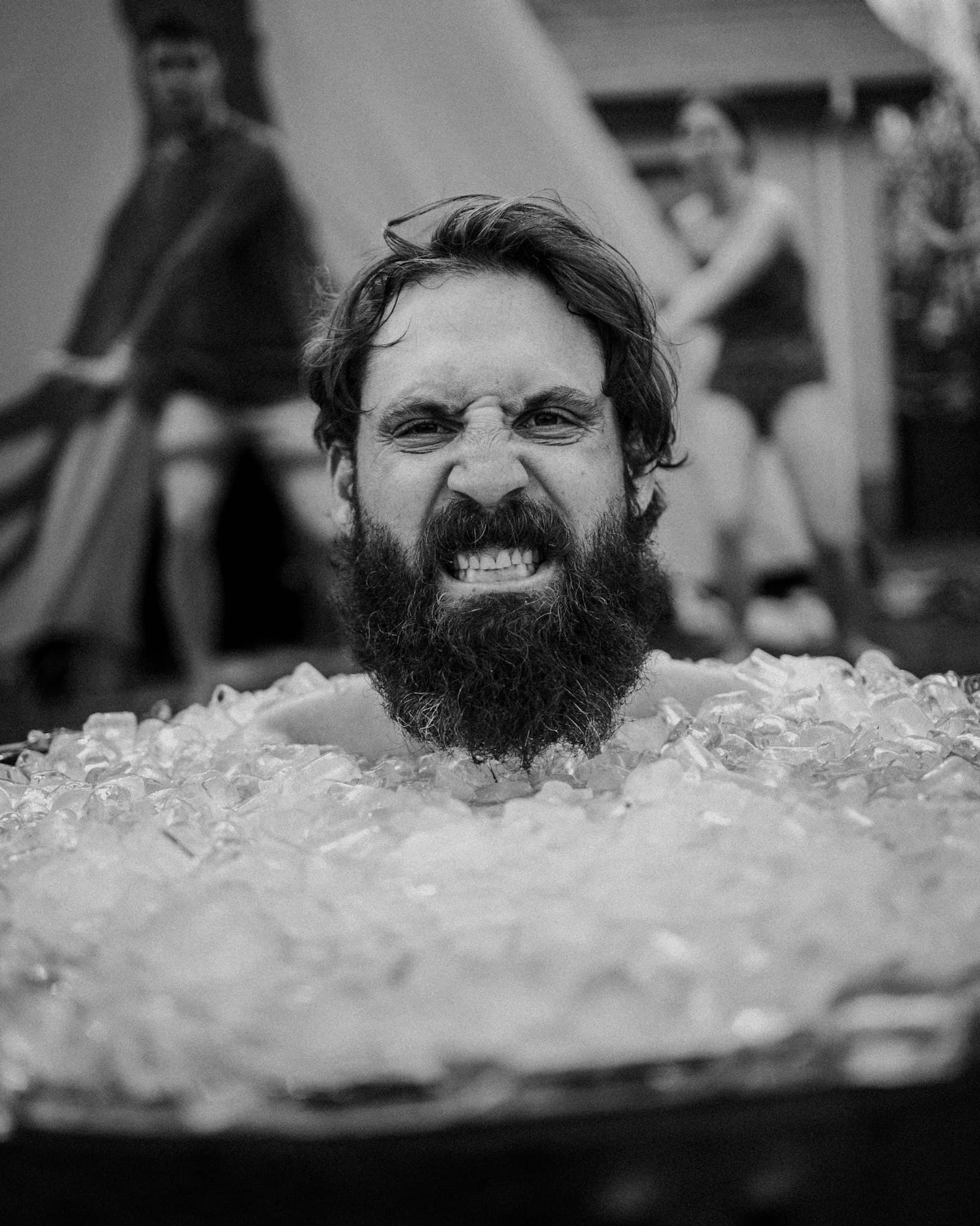Founder mid-cold-plunge in an ice-filled tub, breathing through the shock